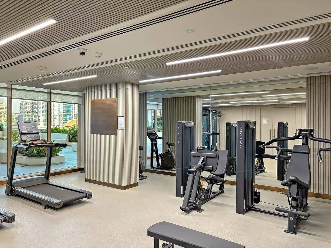 Una sala de fitness con cintas de correr y equipos de musculación.