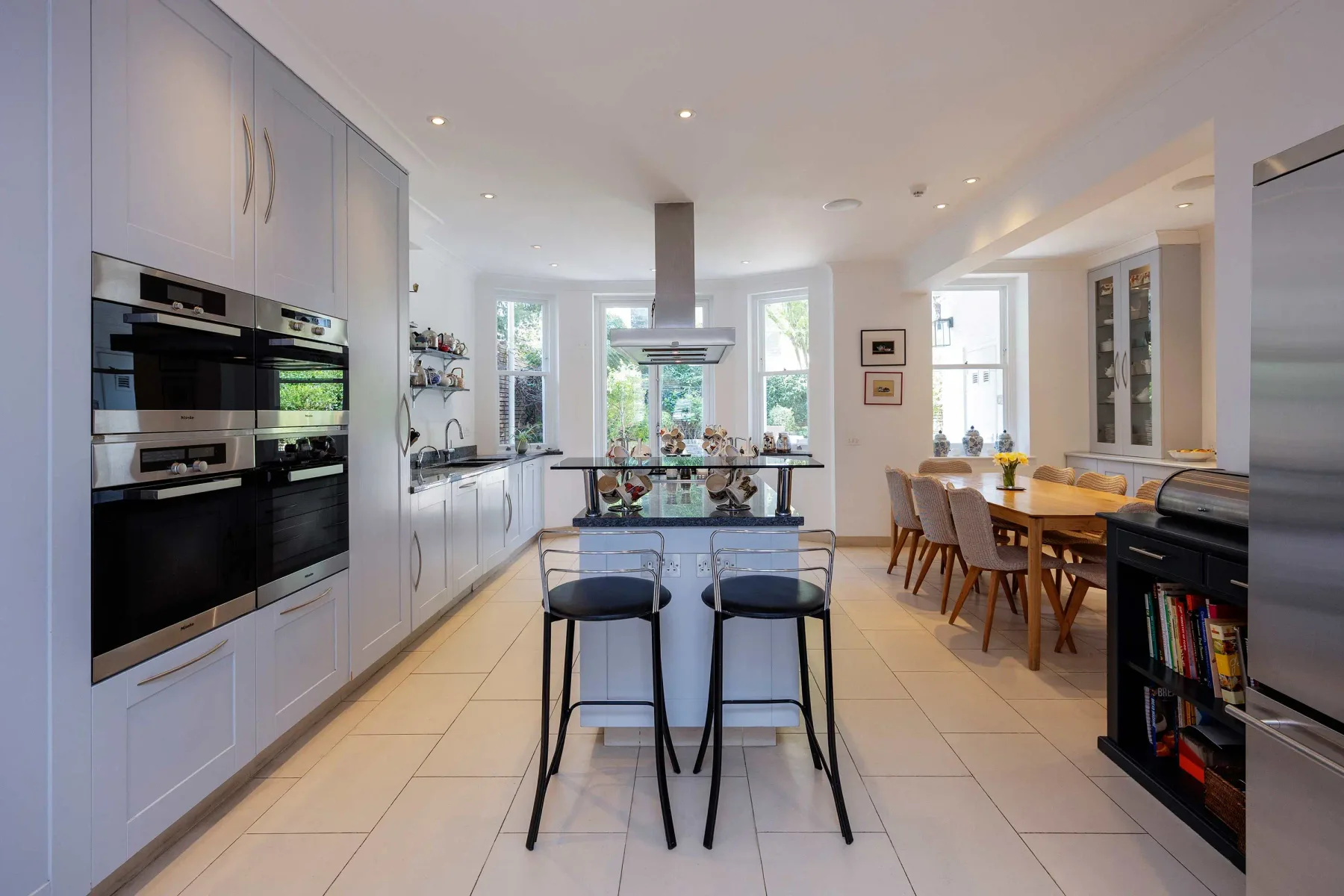 Una cocina luminosa con una isla central y una mesa de comedor.
