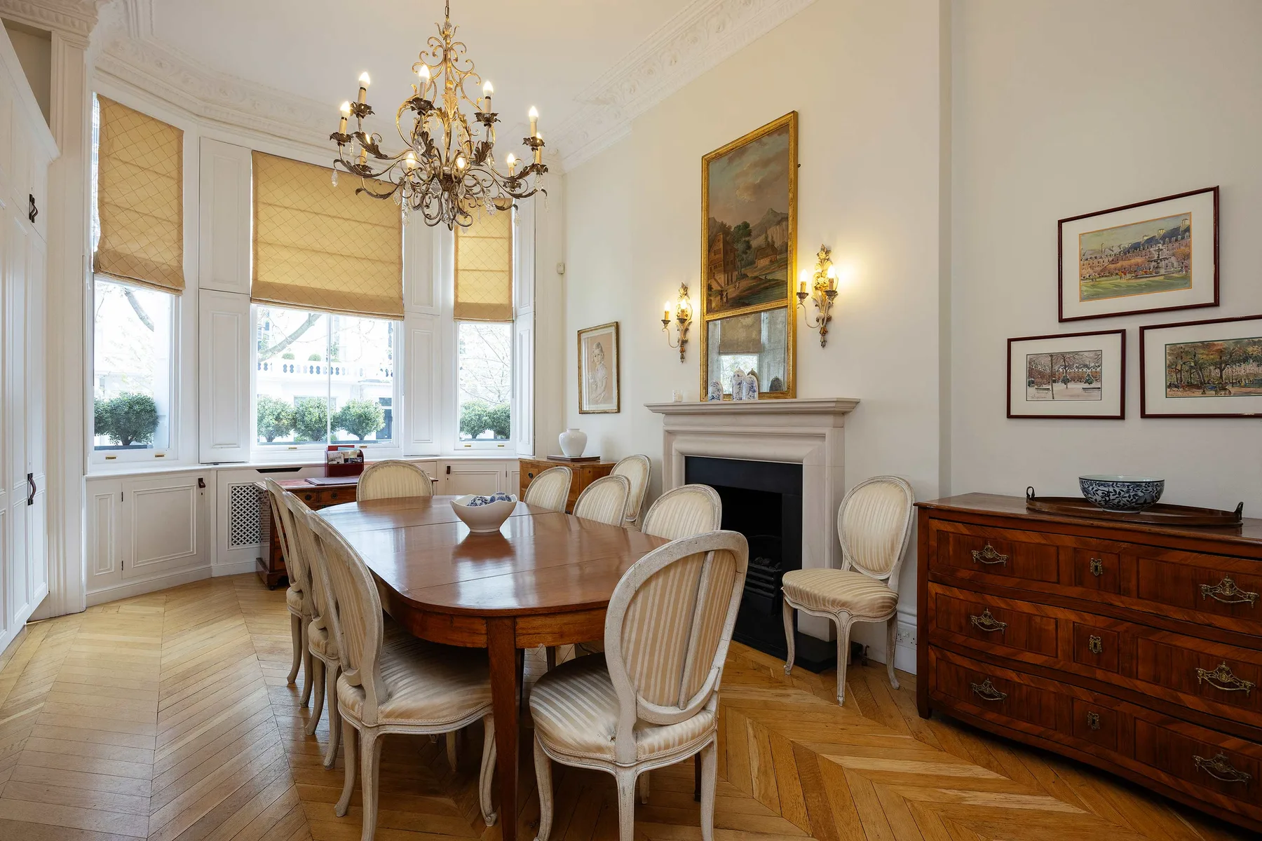 Un comedor formal con una mesa larga de madera y sillas junto a una chimenea.