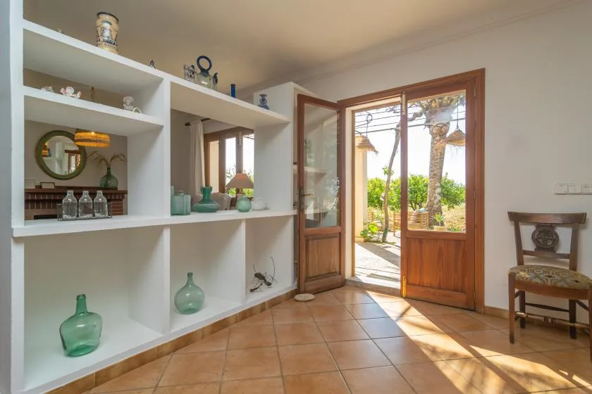 A bright interior room with built-in shelves and an open wooden doorway.