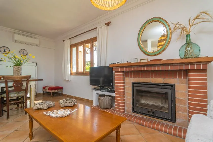 A living room with a brick fireplace and wooden coffee table.