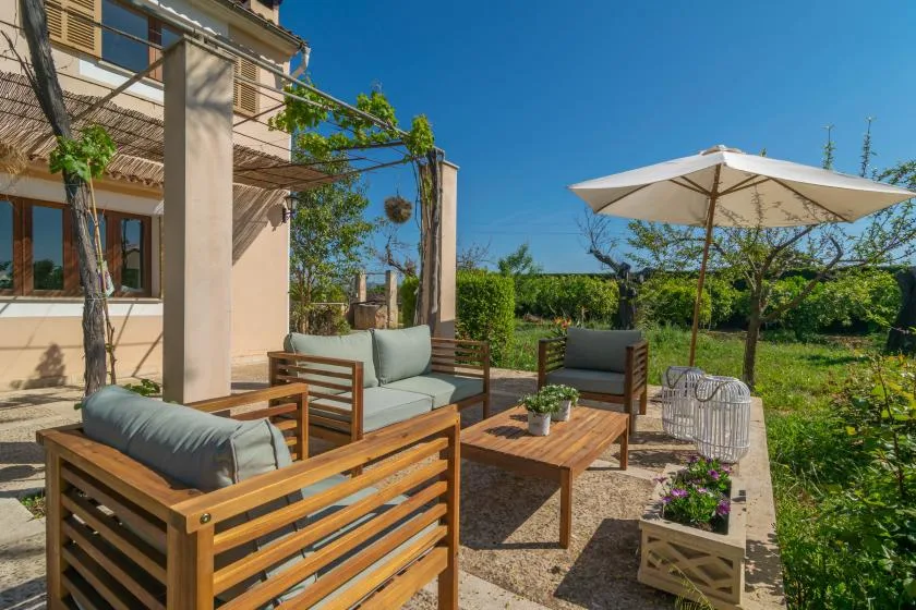An outdoor patio with wooden seating and a large shade umbrella.