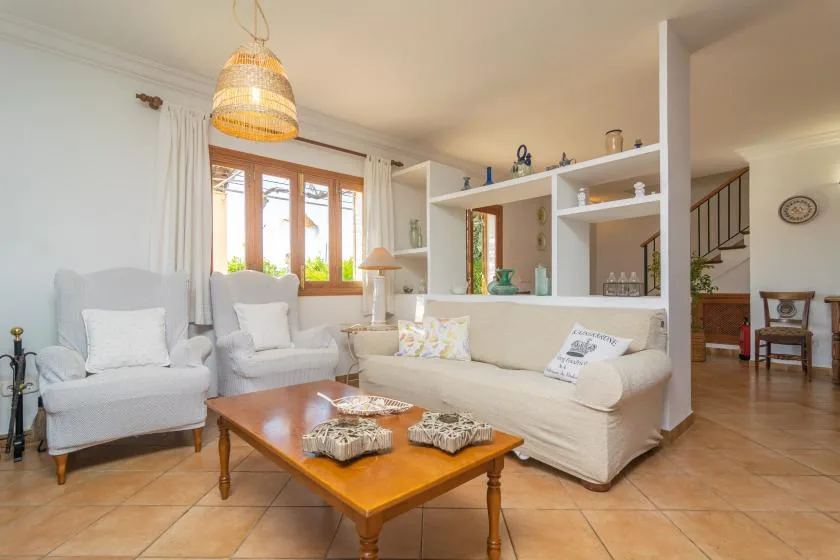 A bright living room with seating around a wooden coffee table.