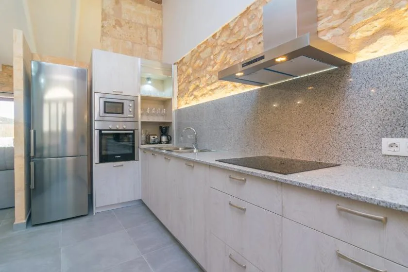 Una cocina moderna con electrodomésticos de acero inoxidable y una encimera larga.