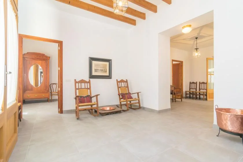 Una habitación interior luminosa con vigas de madera expuestas y asientos.