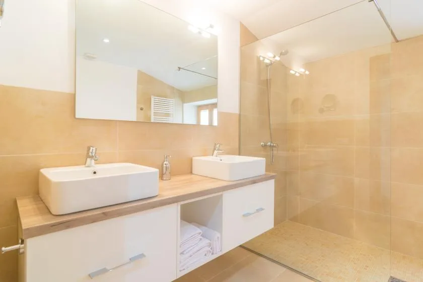 Un tocador de baño con dos lavabos y una ducha a ras de suelo.