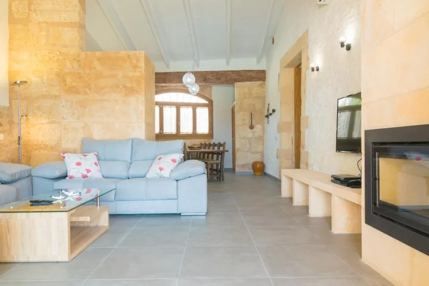 Una sala de estar con asientos claros, una chimenea y una mesa de comedor.