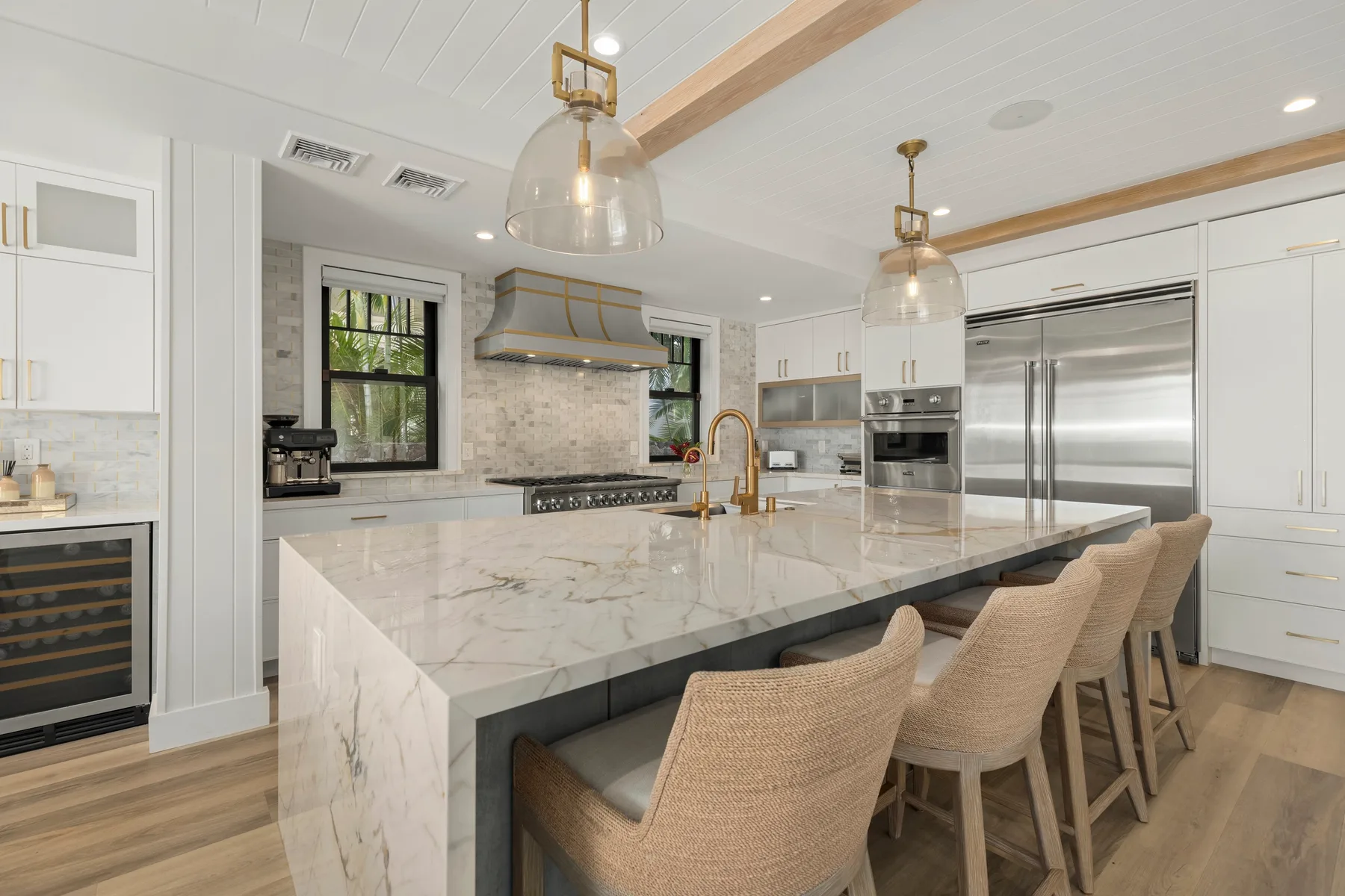 Una cocina luminosa con una isla grande y asientos tejidos.