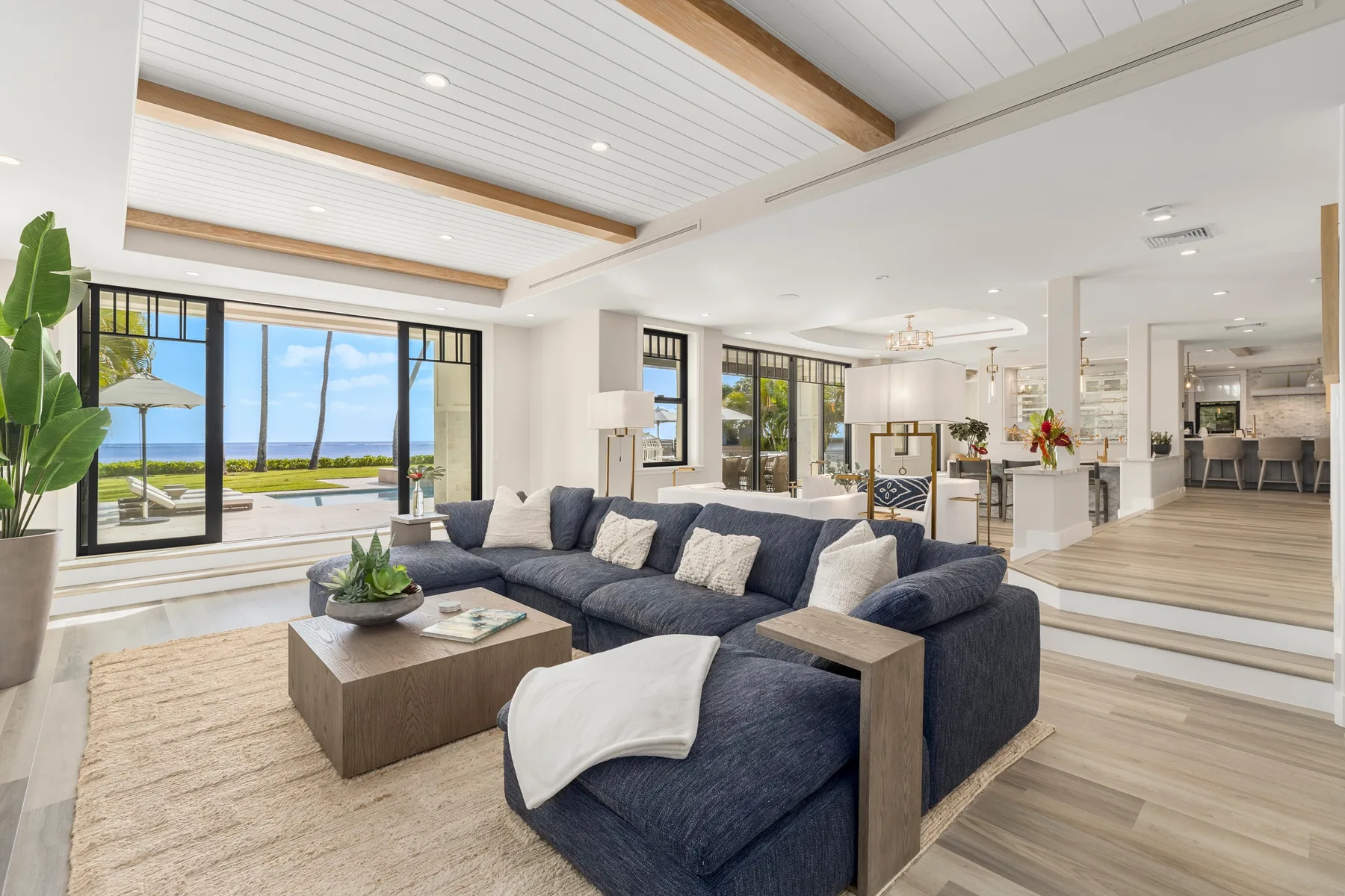 An open living area with a sectional sofa and large windows overlooking the water.