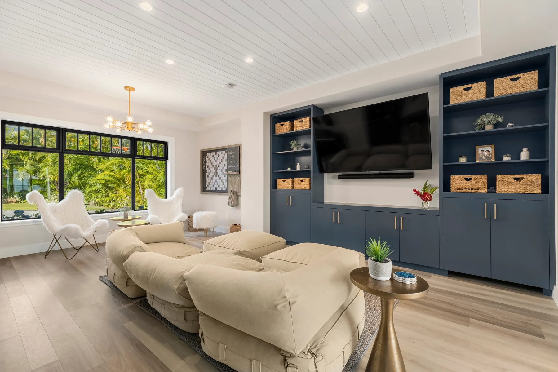 Una sala luminosa con un televisor grande, estanterías empotradas y asientos cómodos.