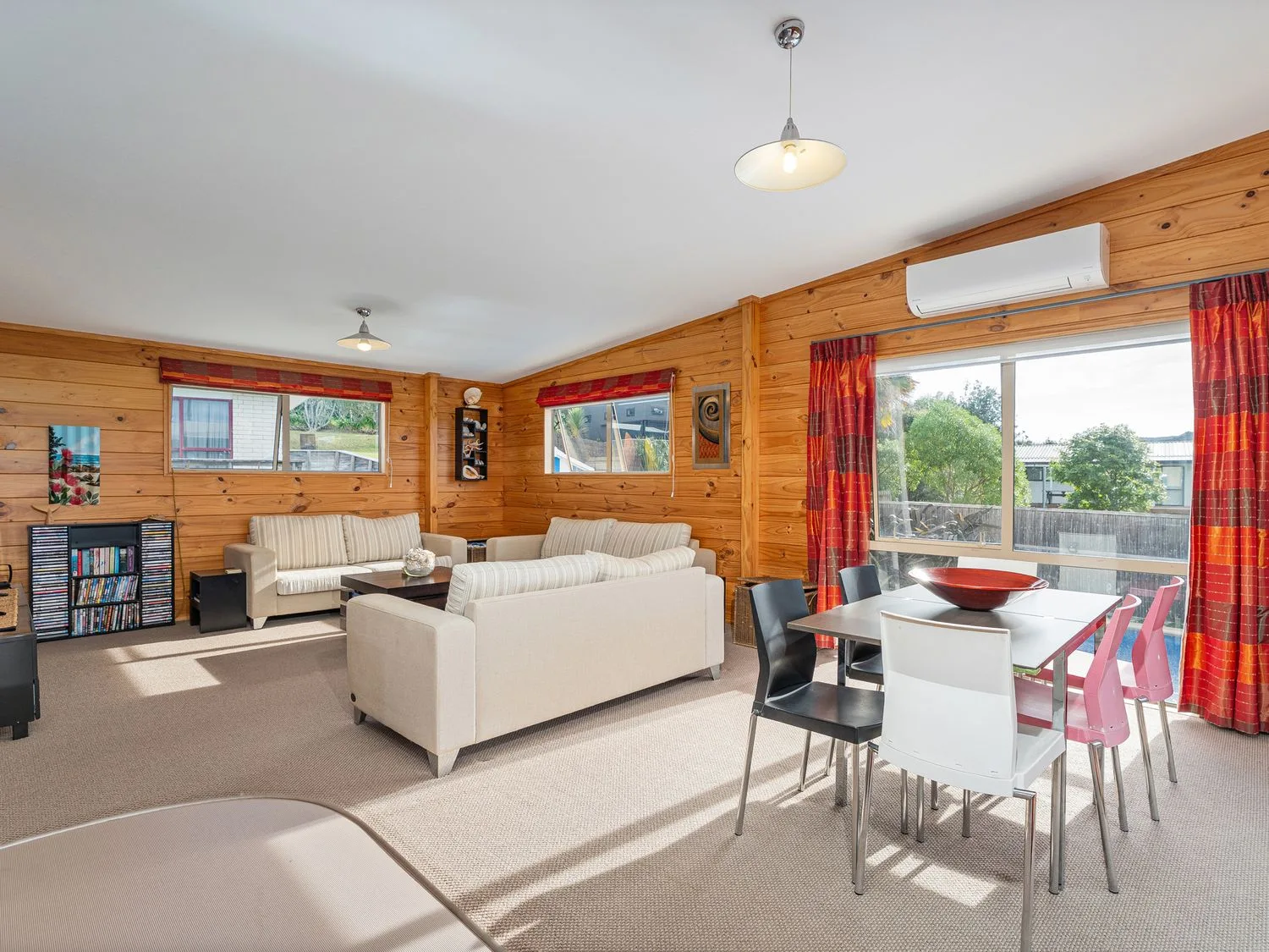 A living room with sofas and a dining area at Whangapoua
