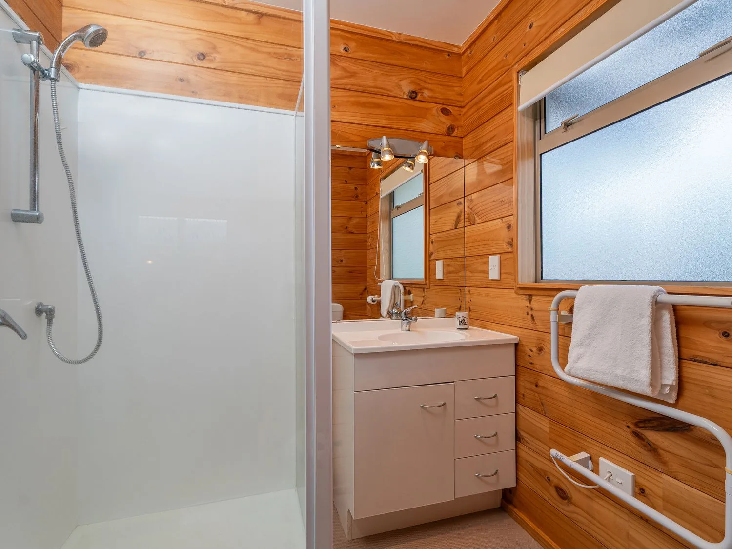 A bathroom with a shower and sink at Whangapoua