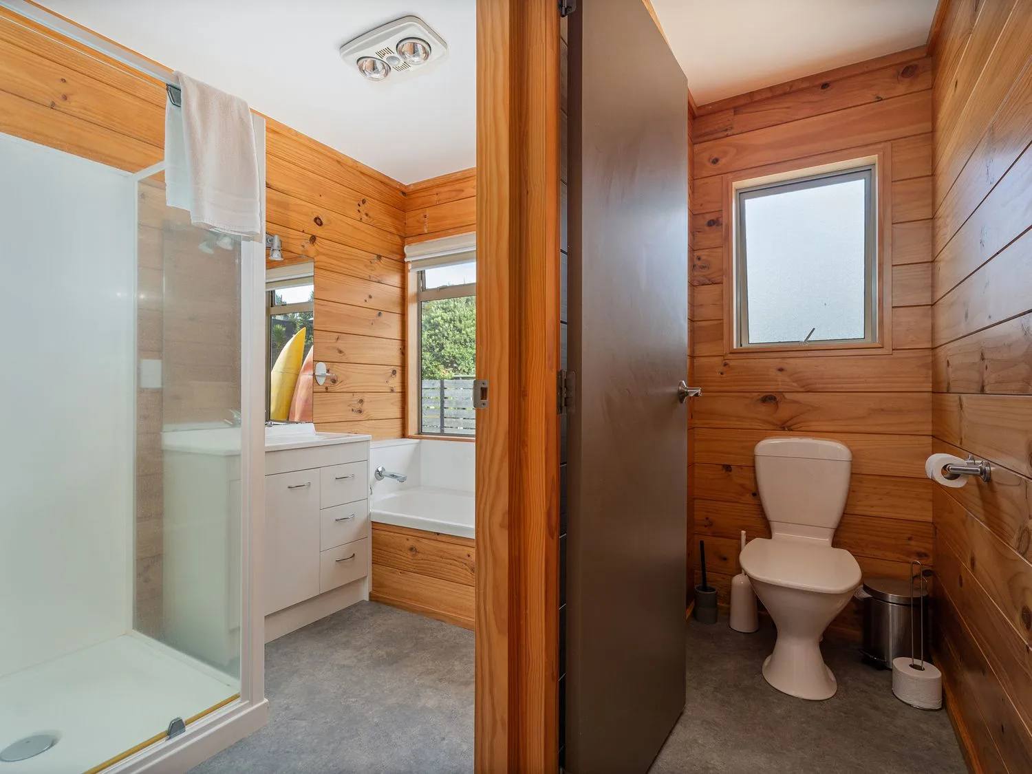 A bathroom with shower, bathtub, sink and toilet at Whangapoua