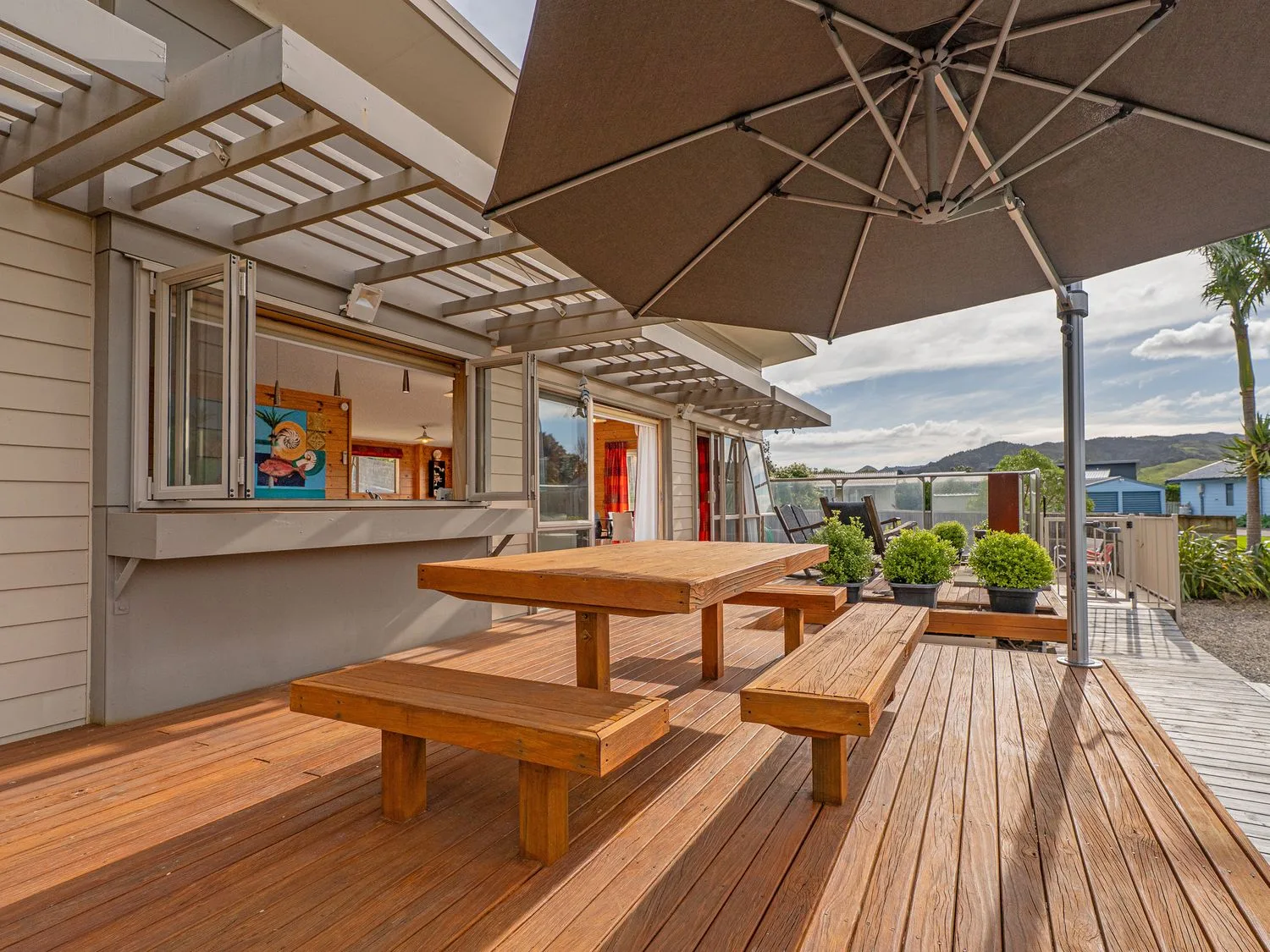 An outdoor seating area with a table and bench at Whangapoua