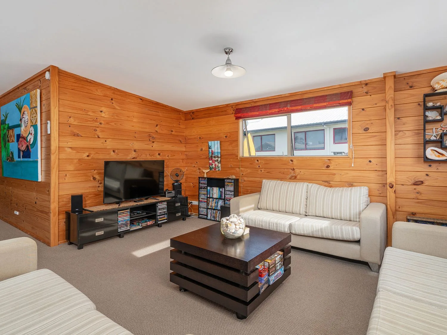 A living room with a television and seating at Whangapoua