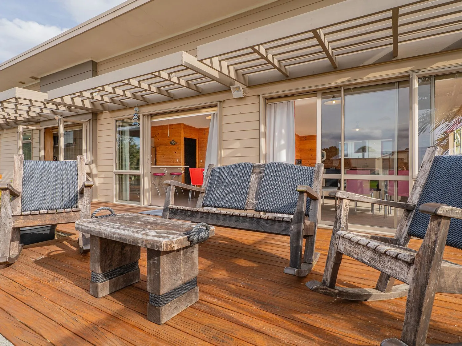 An outdoor seating area with wooden furniture at Whangapoua