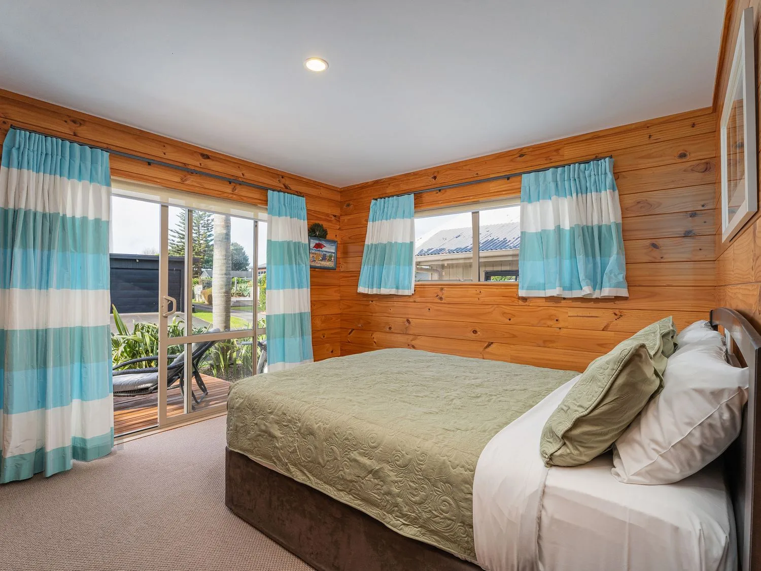 A bedroom with a bed and curtains at Whangapoua