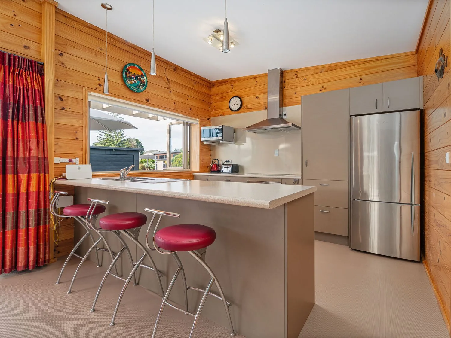 A kitchen with a sink and refrigerator at Whangapoua
