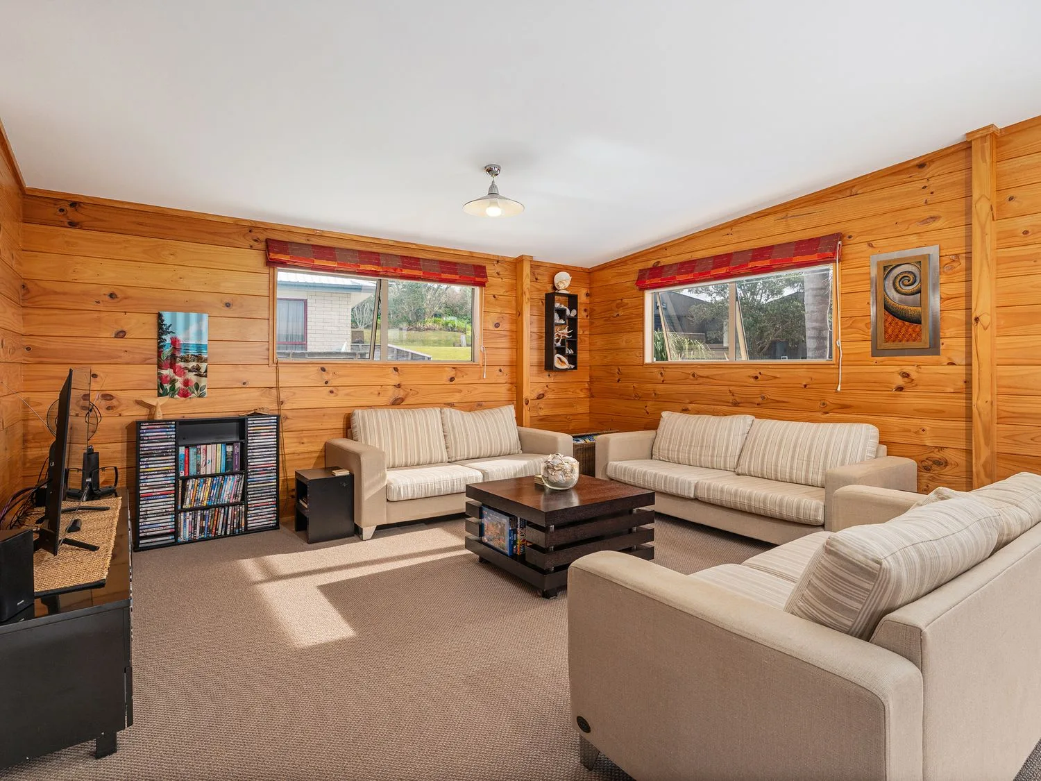 A living room with sofas and a television at Whangapoua