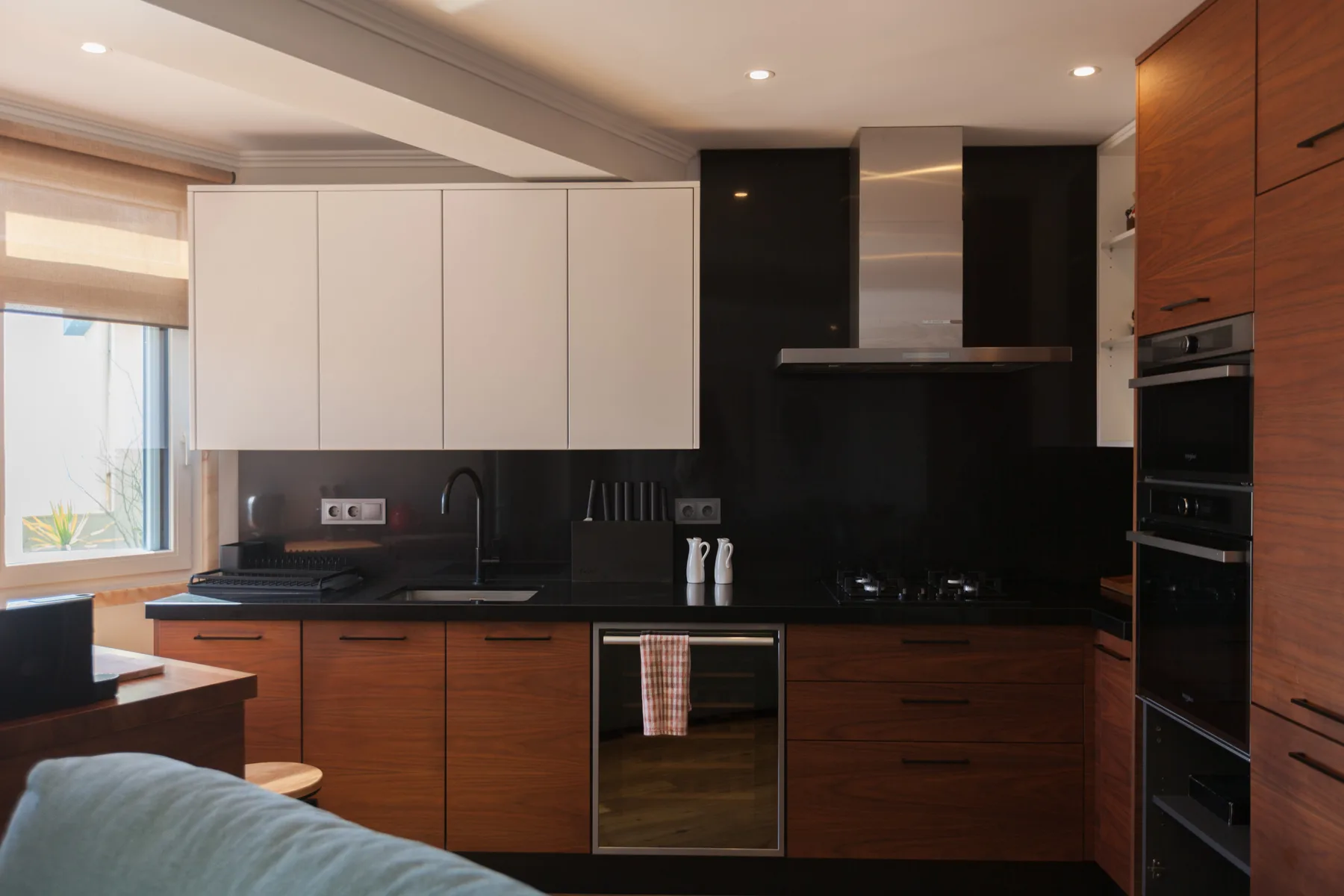 Una cocina moderna con encimeras oscuras y armarios de madera.