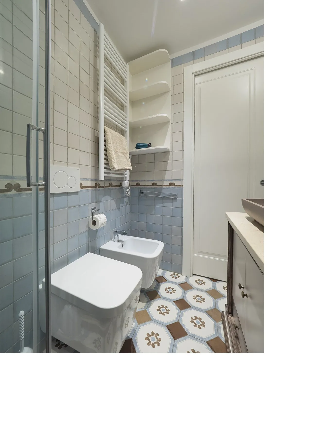 Un baño alicatado con inodoro, bidé y lavabo.