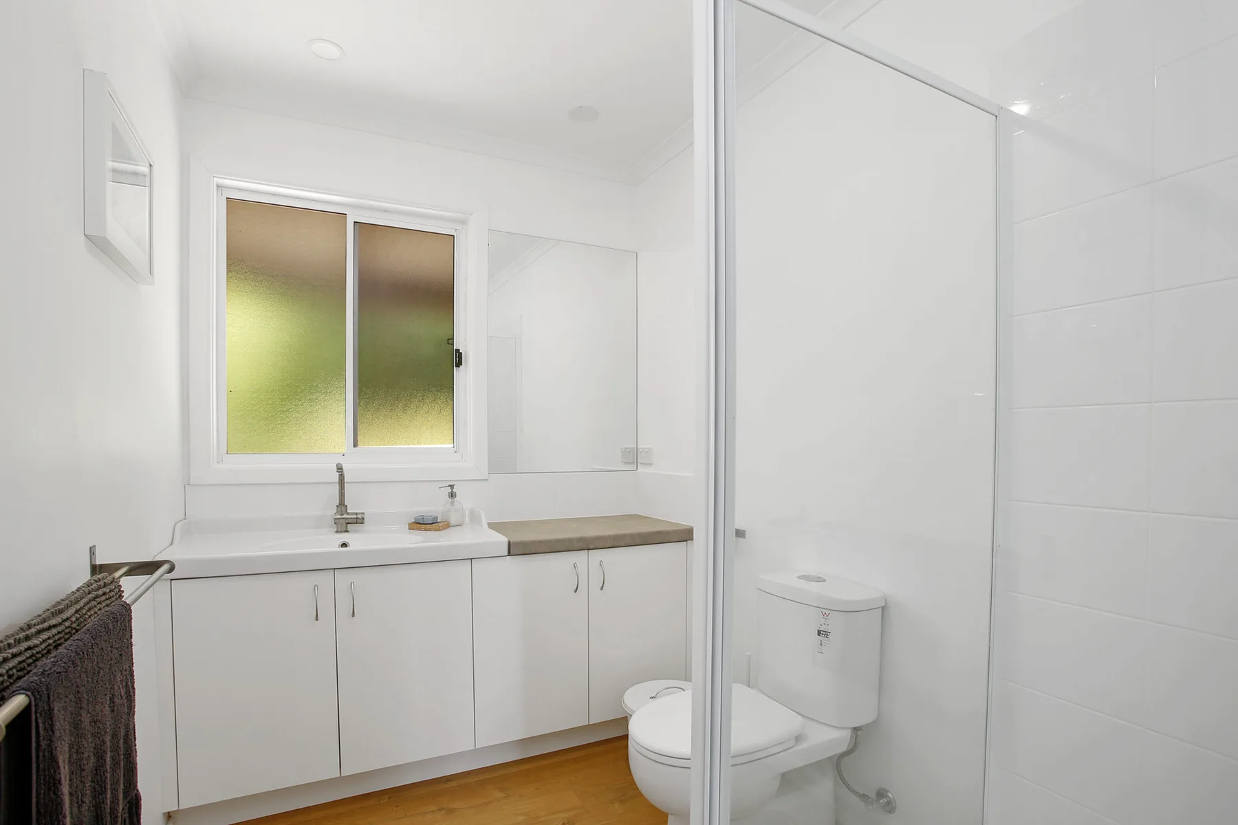 A bright bathroom with a sink, vanity, and shower.