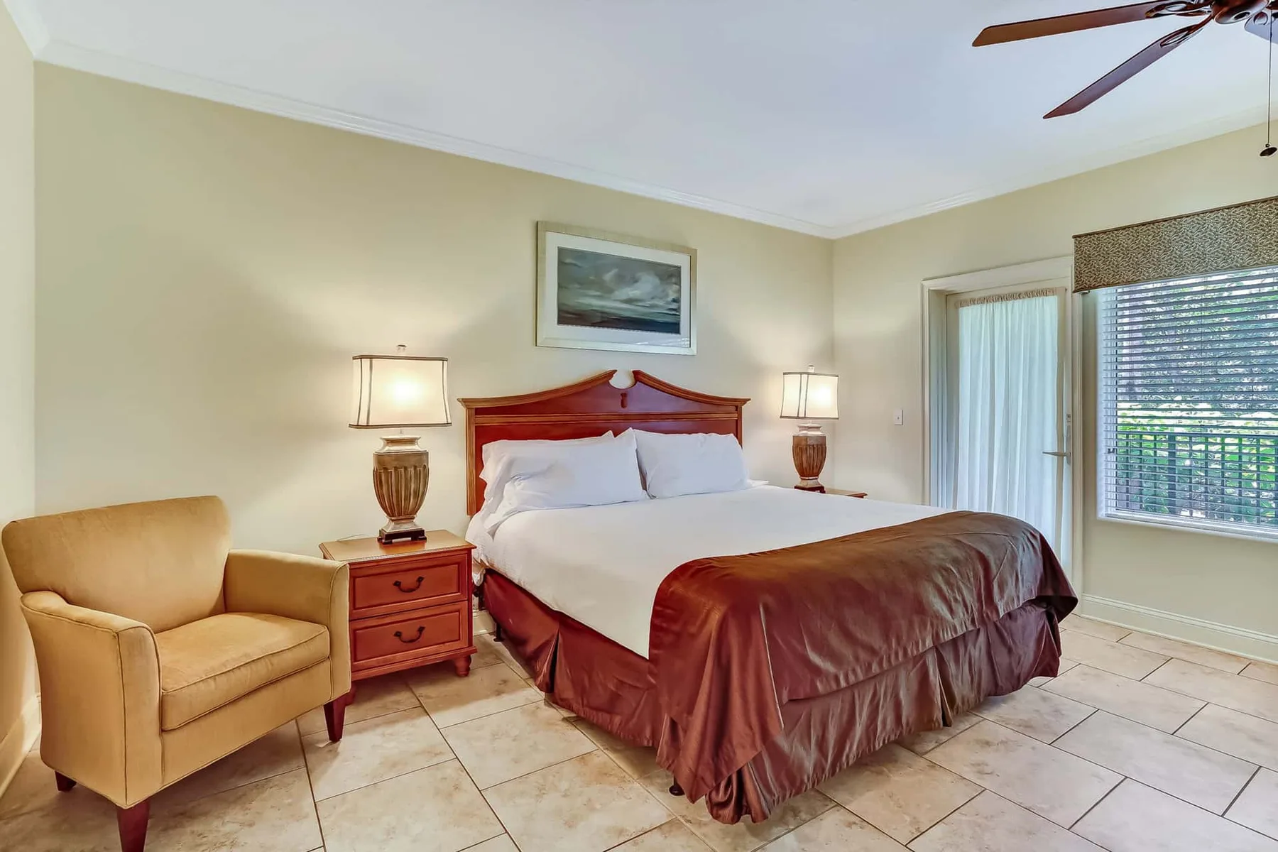 A bedroom with a large bed, bedside tables, and a window.