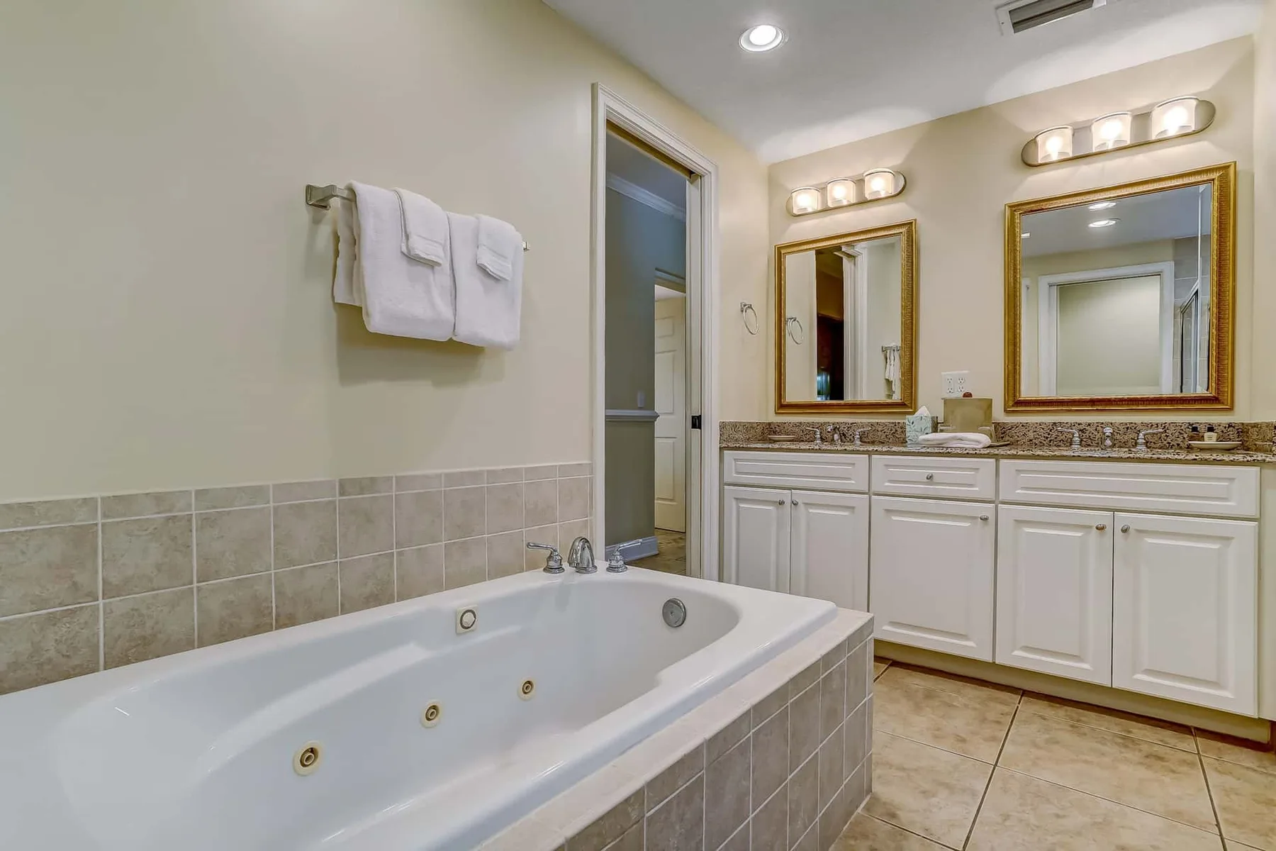 A bathroom with a large soaking tub and a double-sink vanity.
