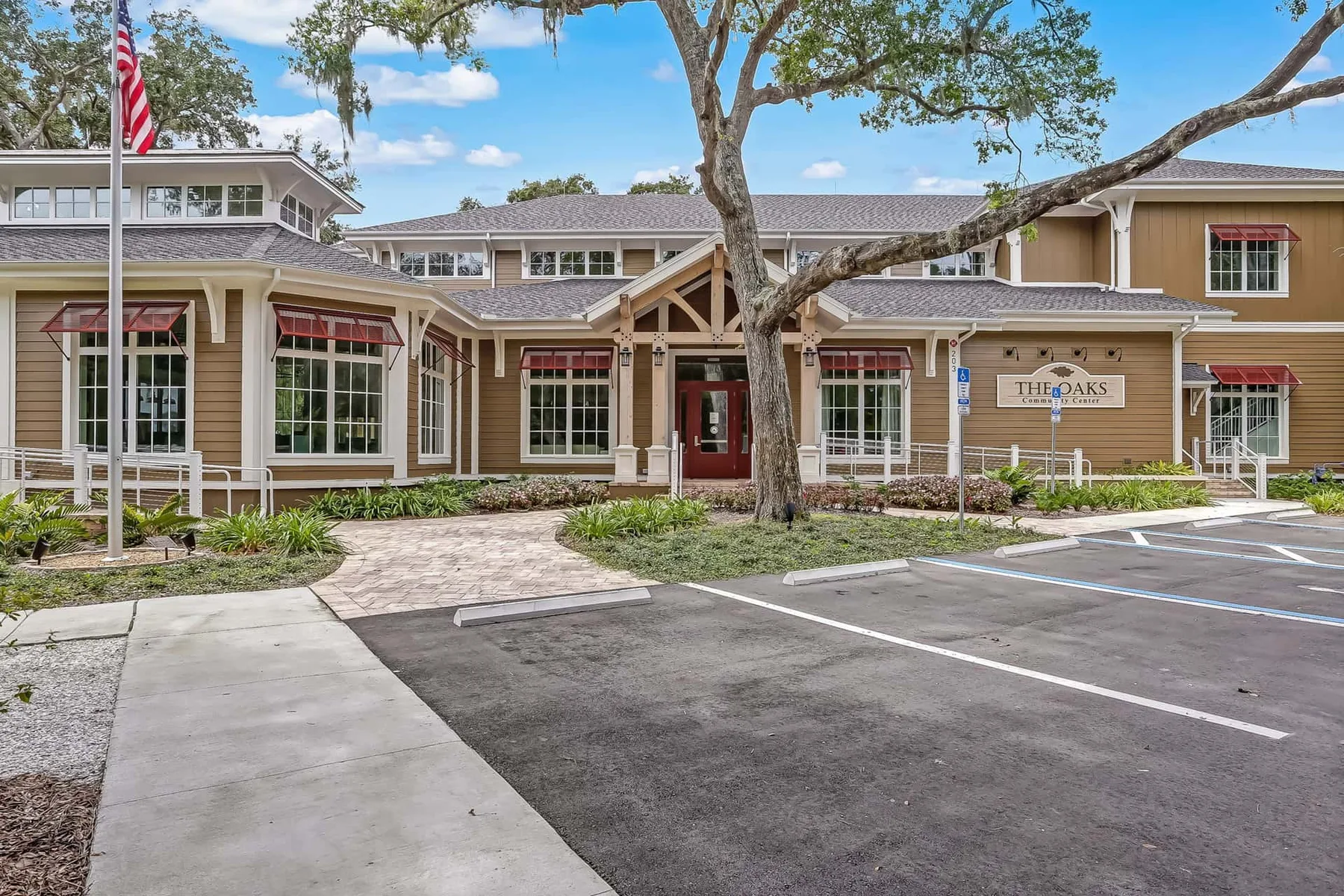 A low-rise building with a covered entrance, landscaping, and a paved parking area.