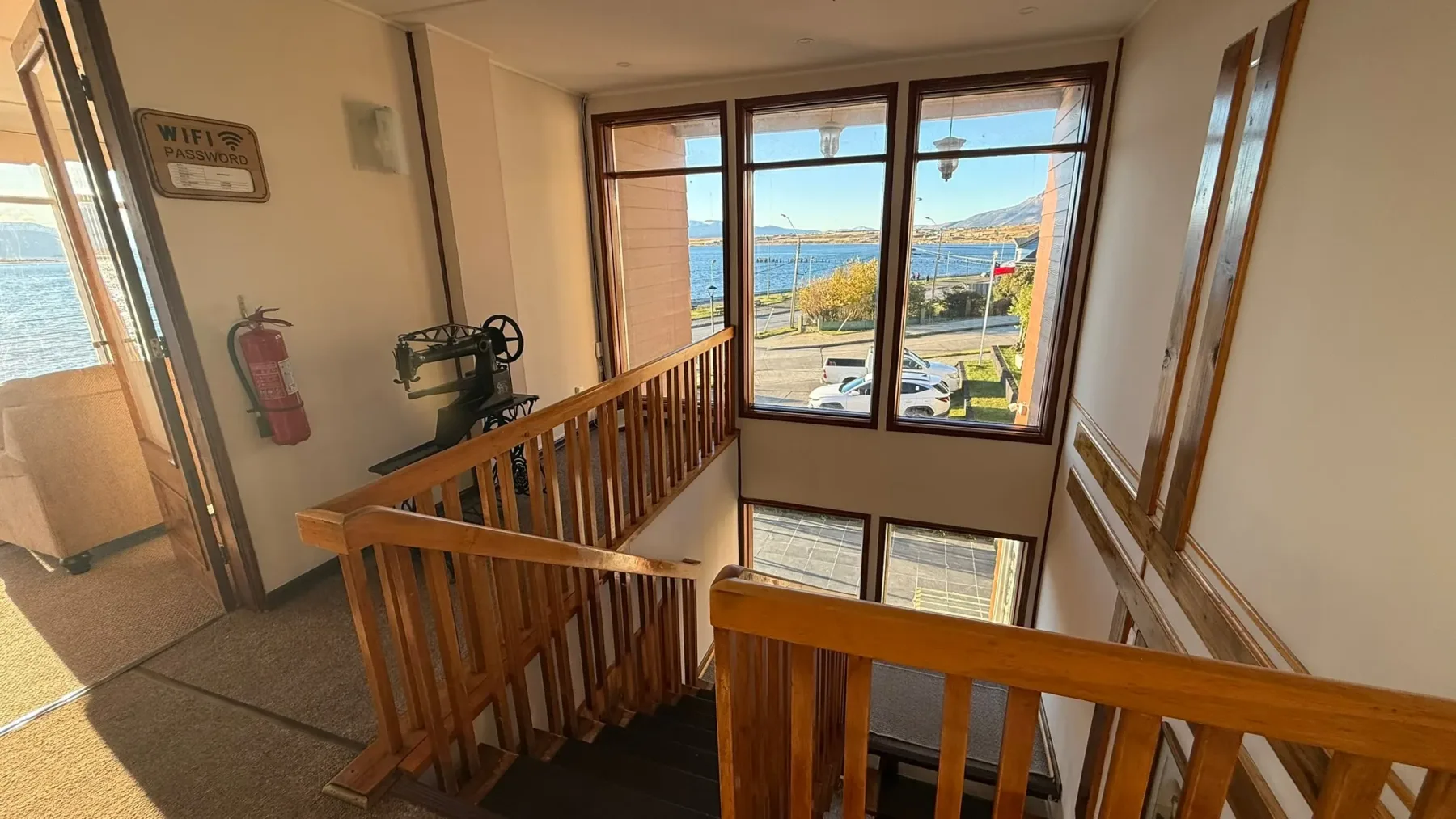 Wooden staircase with a vintage sewing machine and a window toward the fjord