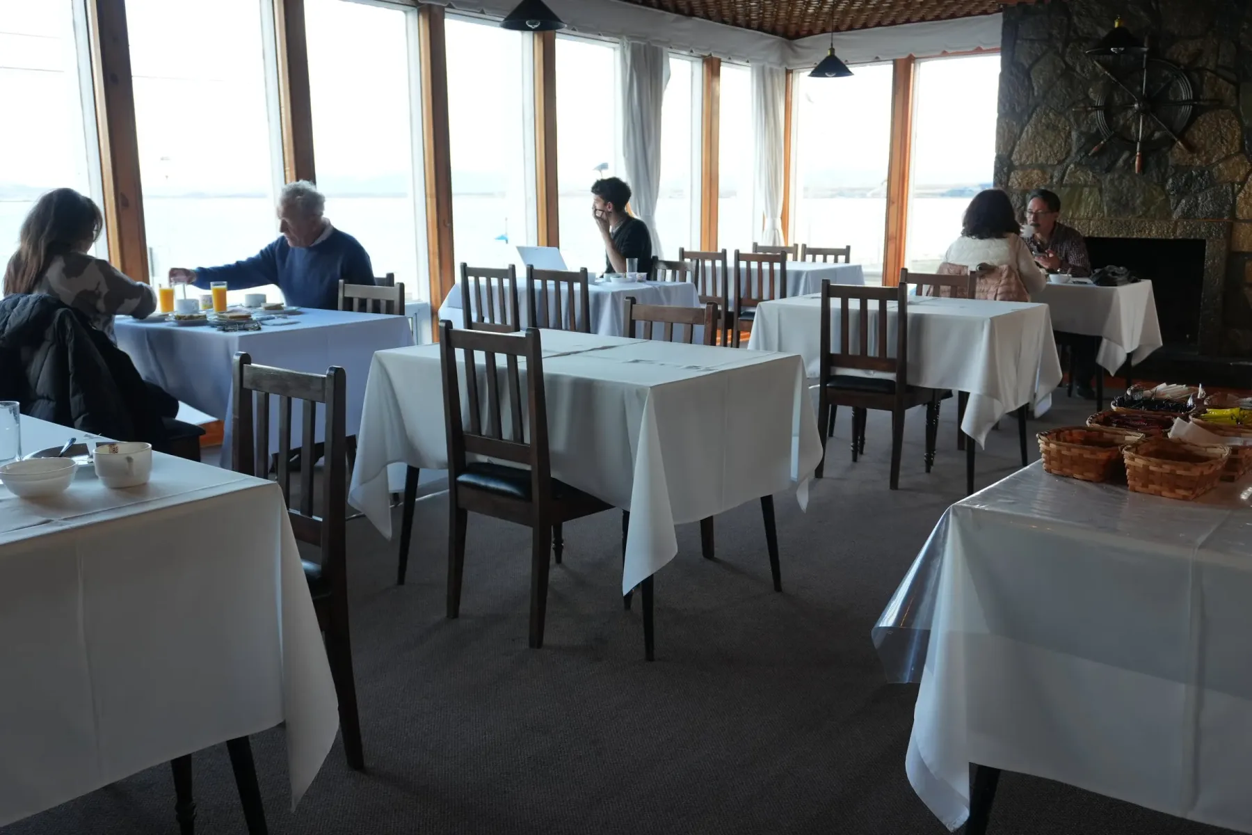 Comedor con mesas junto a ventanas con vistas al fiordo