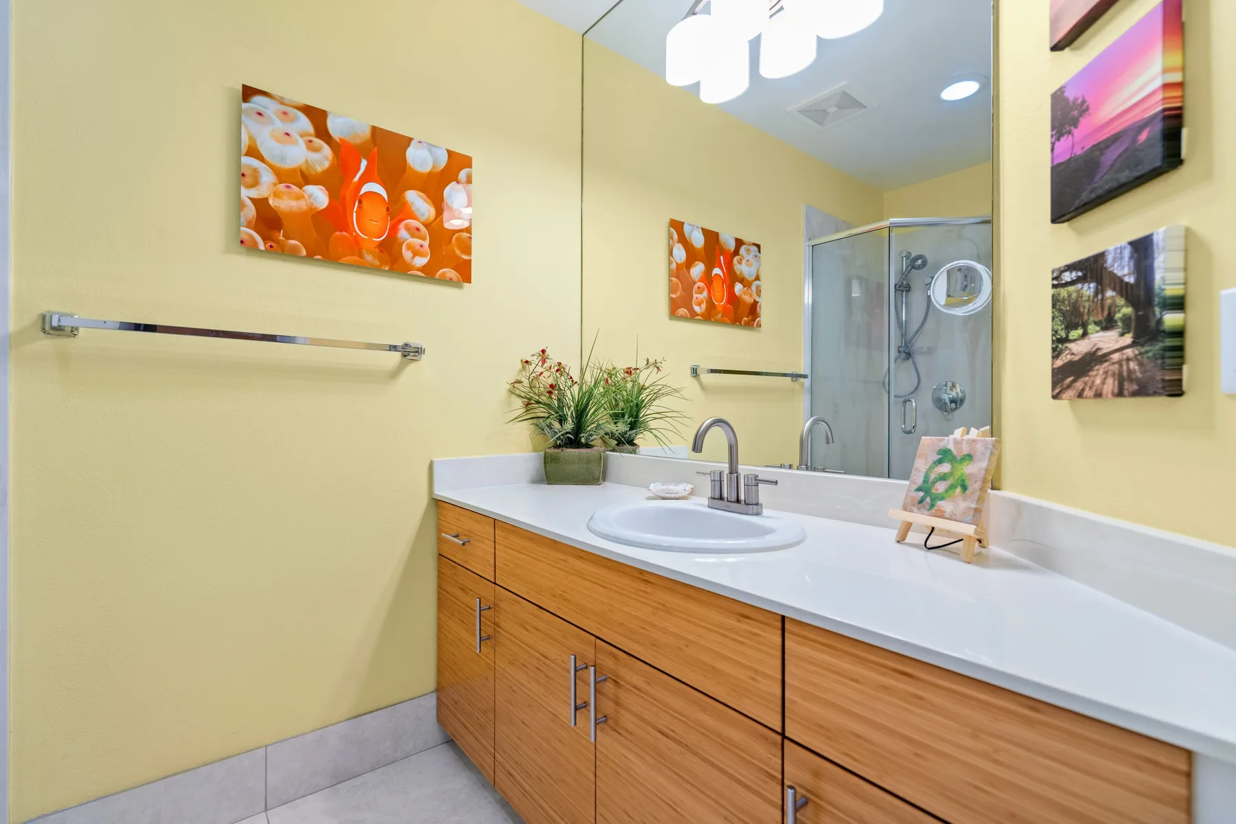Un baño con una encimera blanca y una ducha de vidrio.