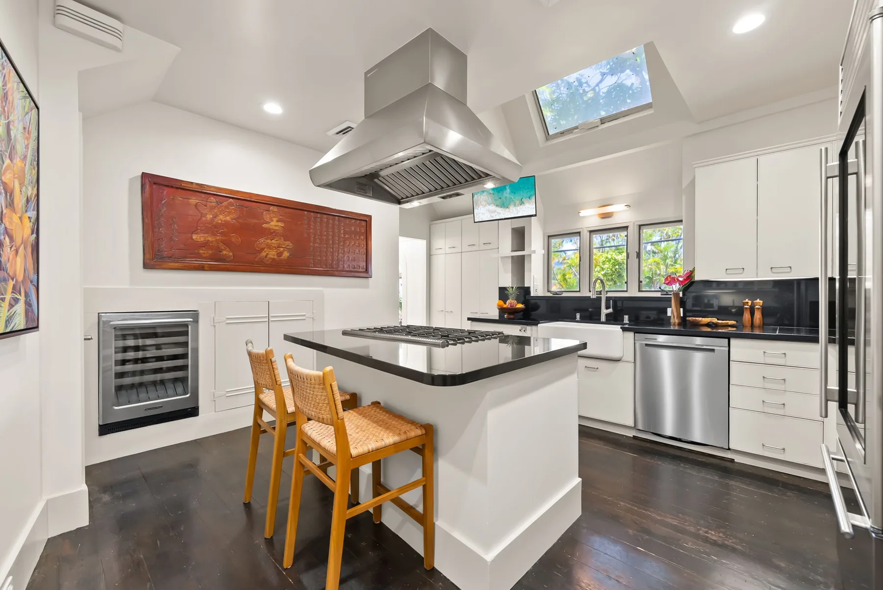 Una cocina moderna y luminosa con una isla central y asientos de madera.