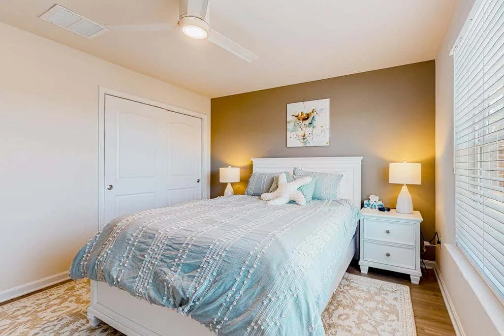 Un dormitorio con una cama frente a una pared decorativa marrón.