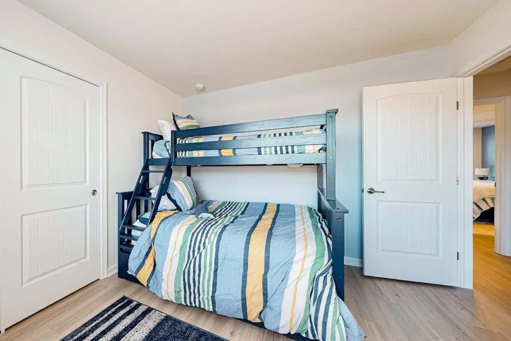 Un dormitorio con una litera vestida con ropa de cama a rayas.