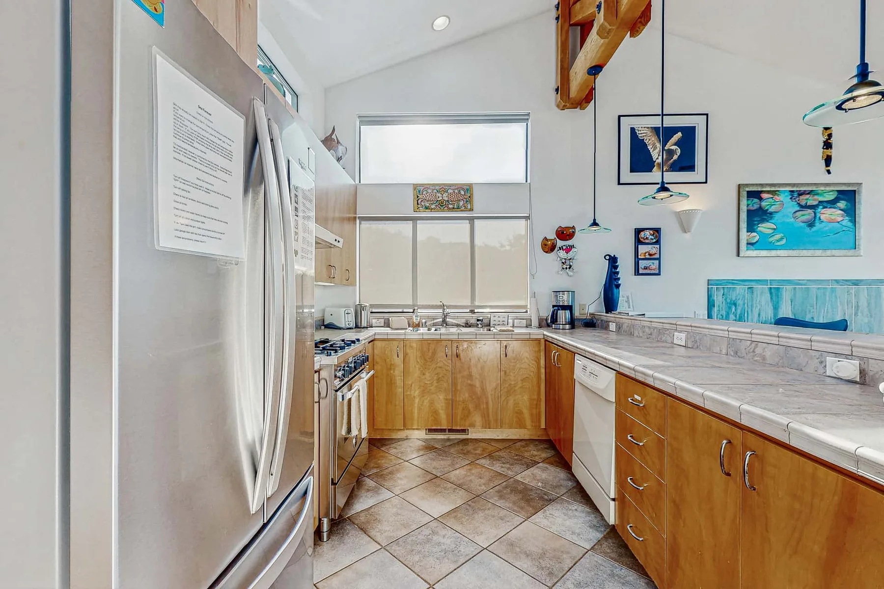 A bright kitchen with wooden cabinets and long countertops.
