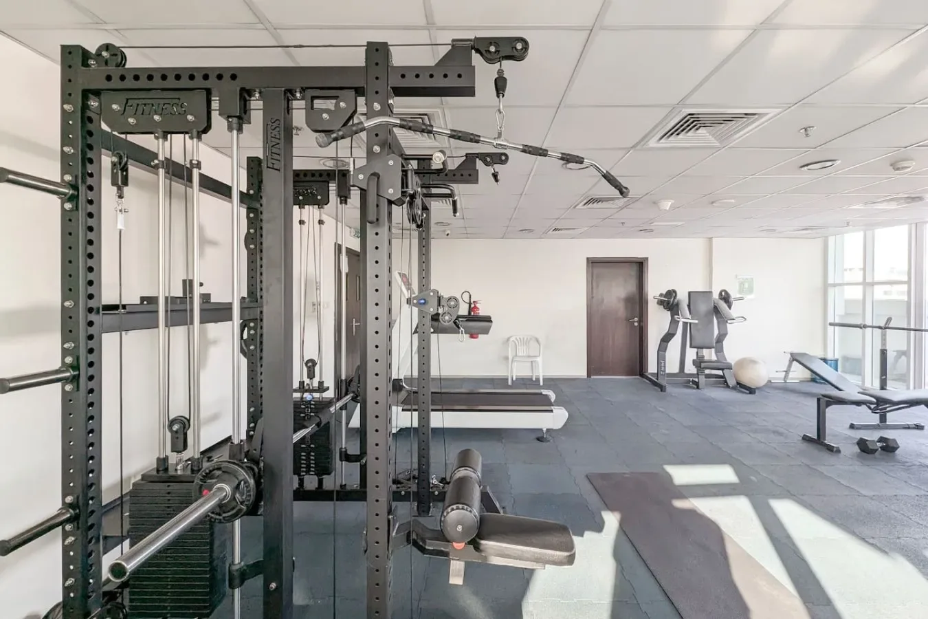 A bright gym with weight-training equipment and exercise machines.