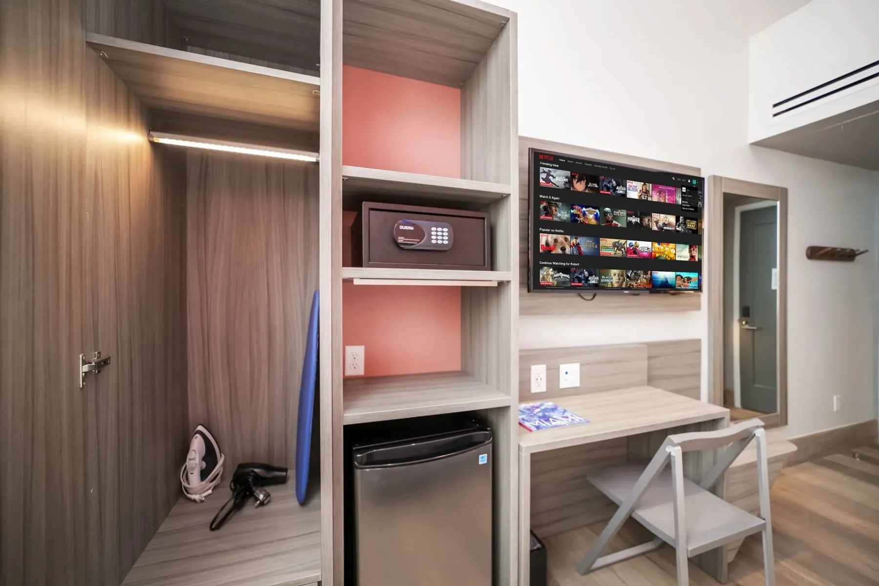 Double Height King Suite interior with a wardrobe, TV, desk, and safe.