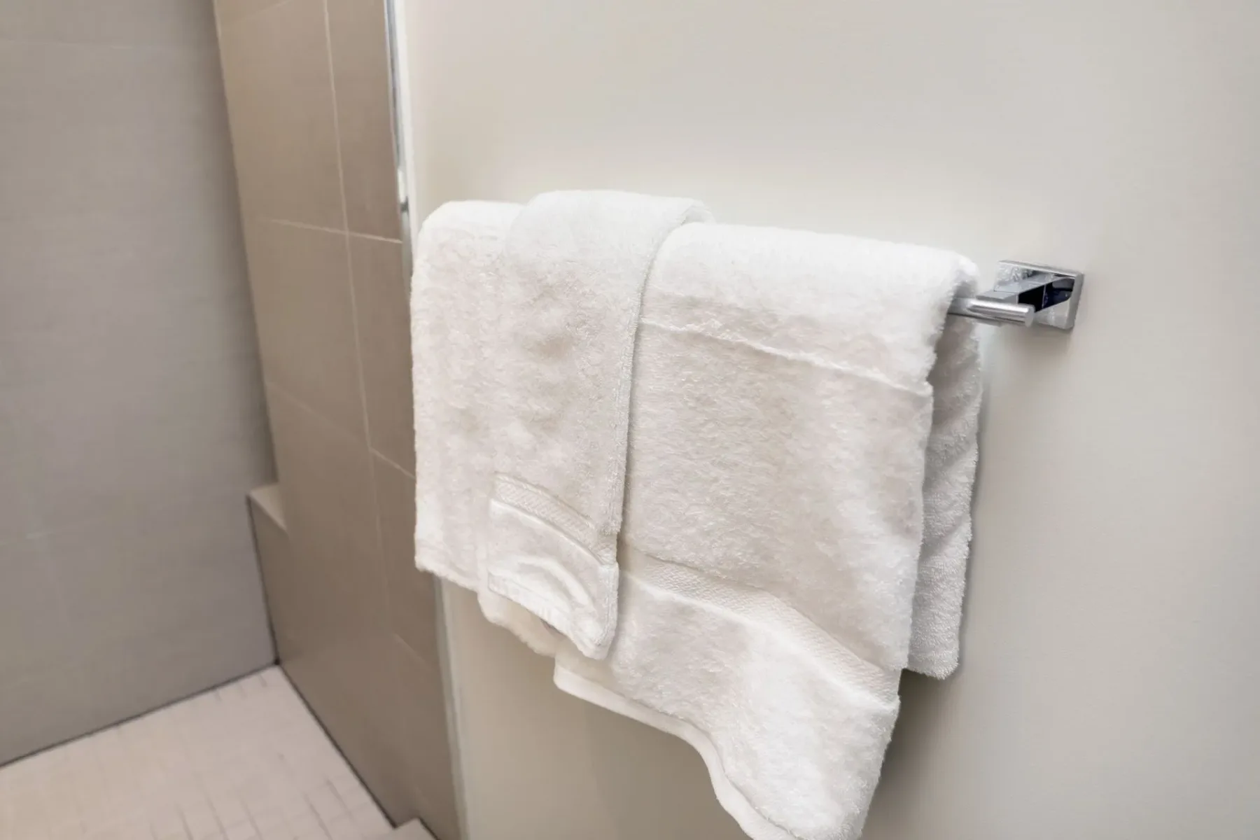 Bathroom towels on a chrome towel bar.