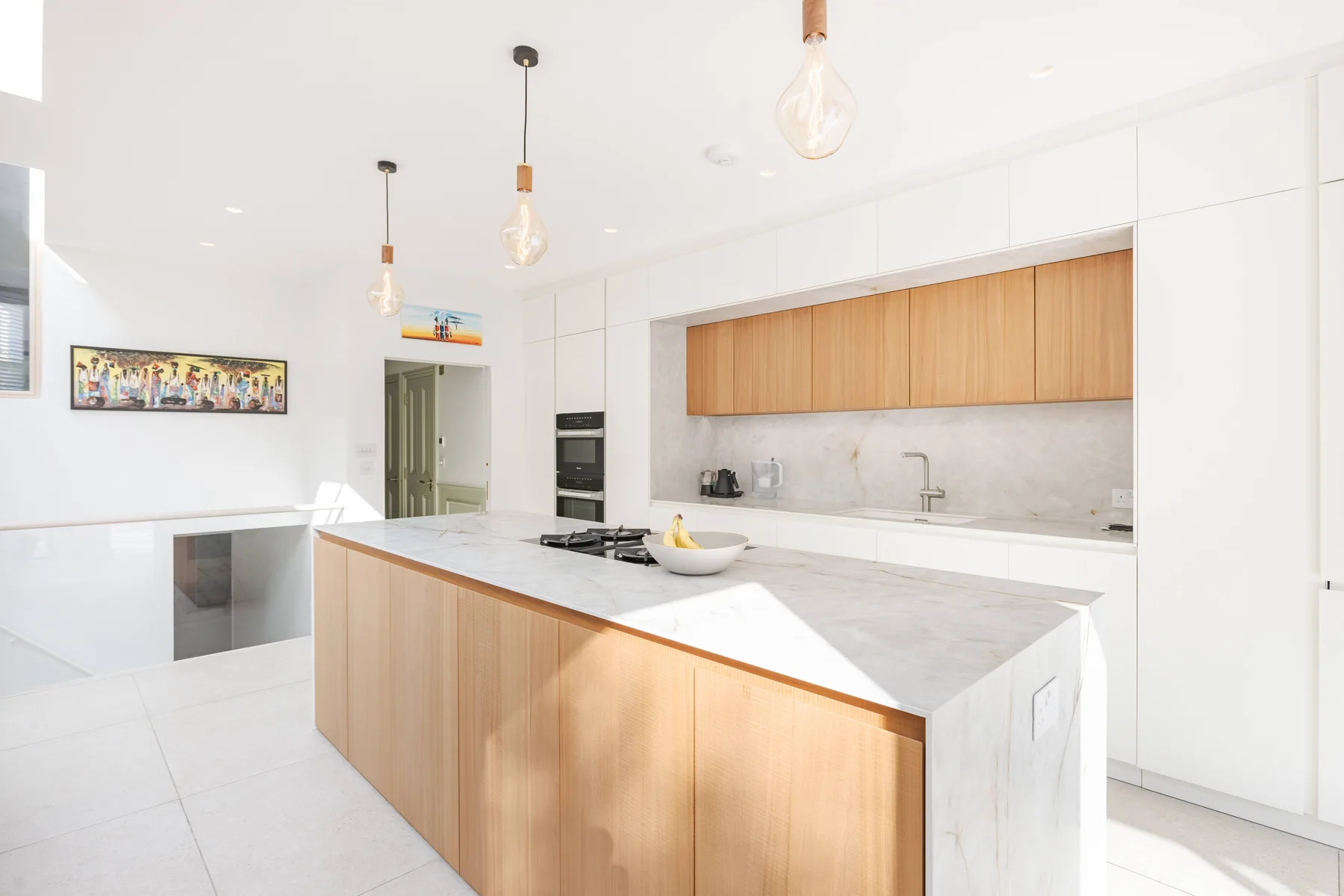 Una cocina moderna y luminosa tiene una isla grande con una encimera clara.