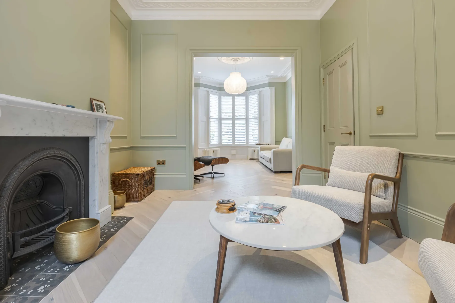 Una sala de estar clara con chimenea y asientos alrededor de una mesa de centro.