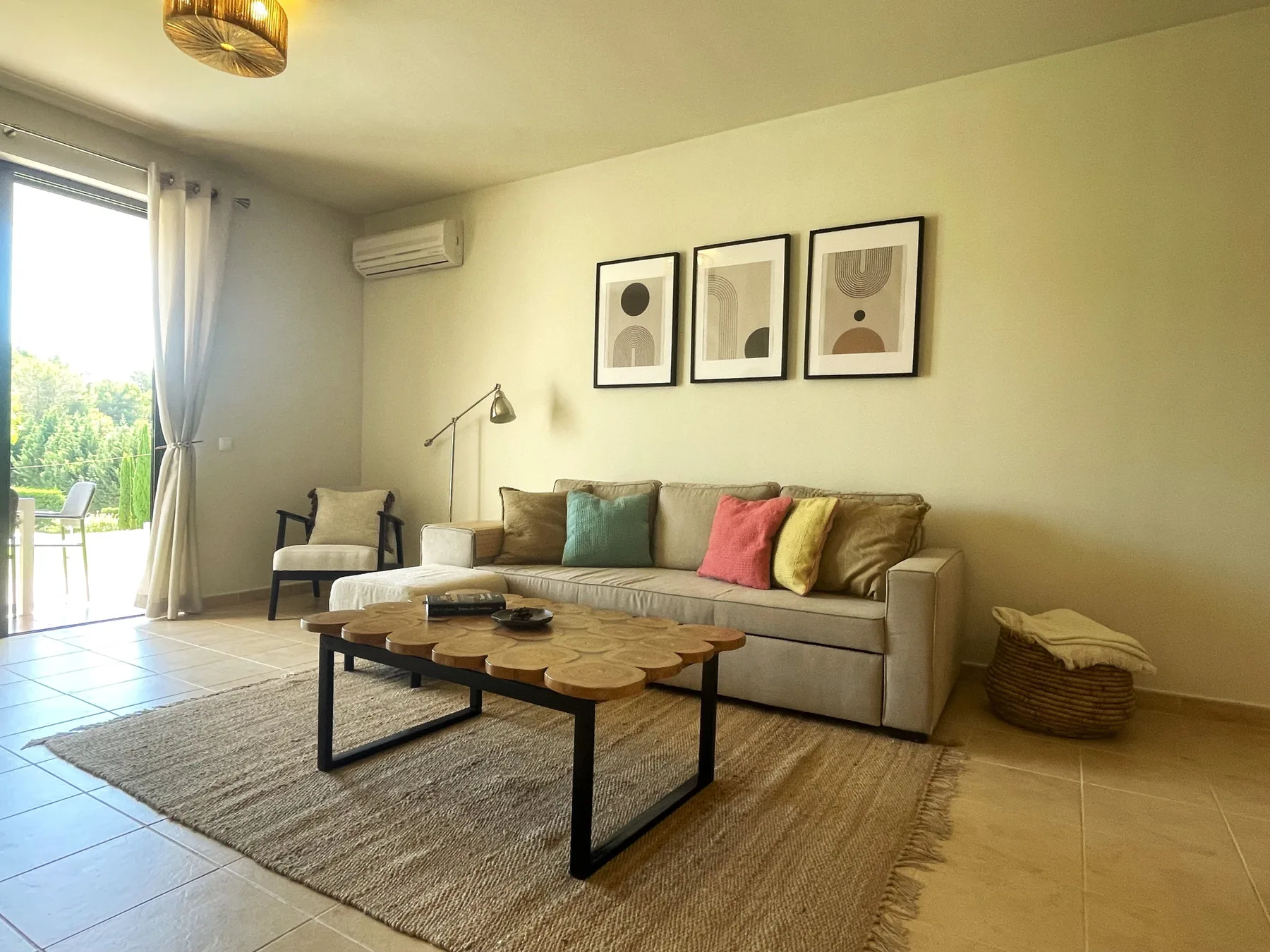A living room with a sofa, coffee table, and sliding glass doors opening to a patio.