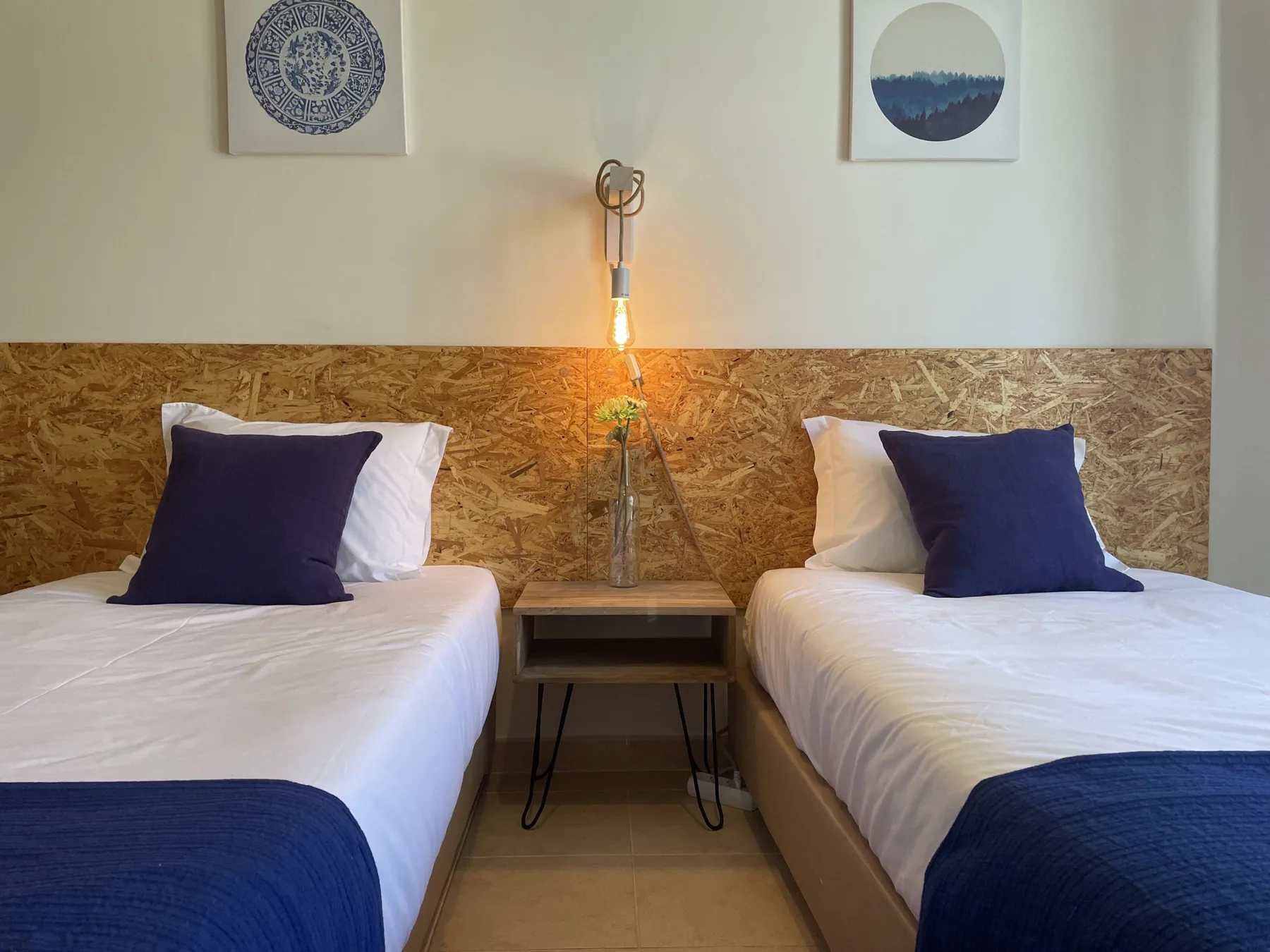 A bedroom with two single beds and a small table between them.
