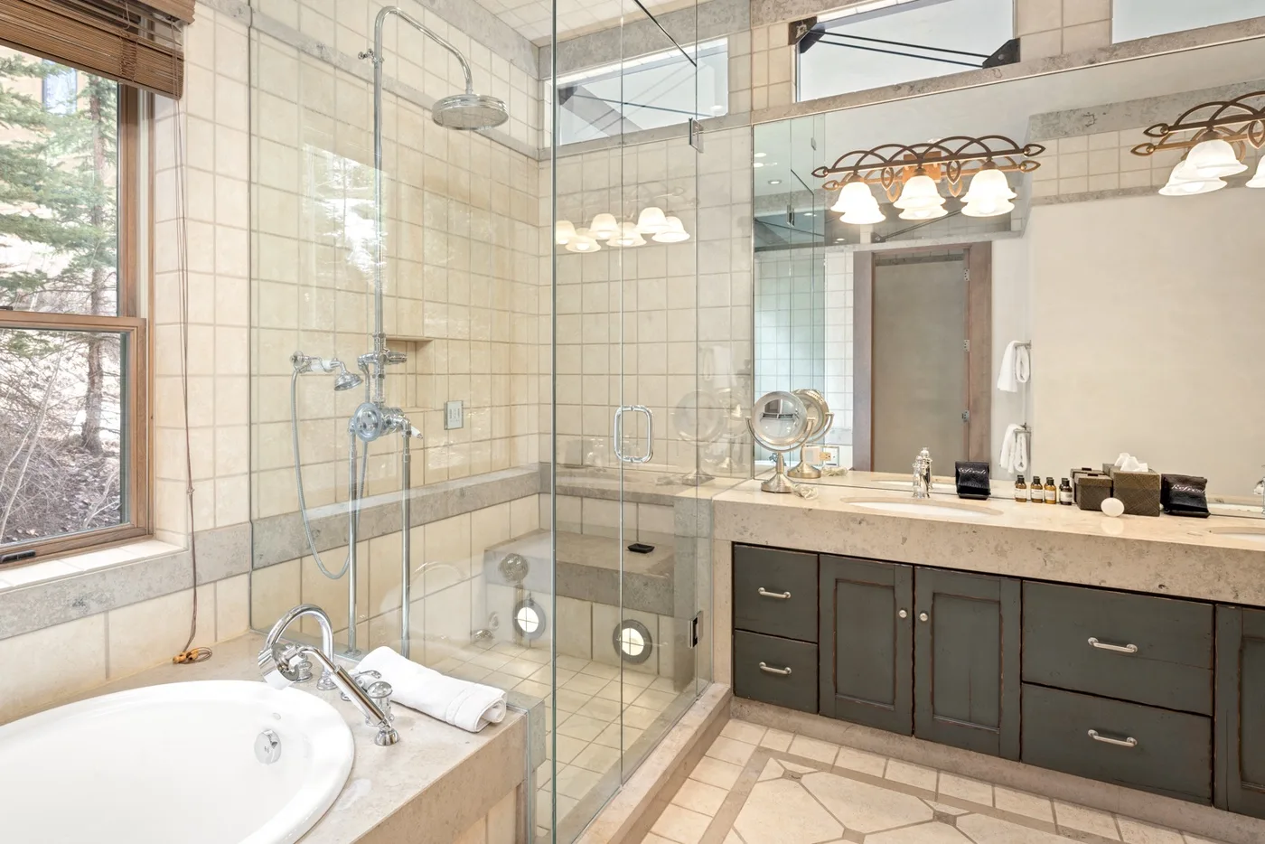 A bright bathroom with a bathtub, glass shower, and vanity.