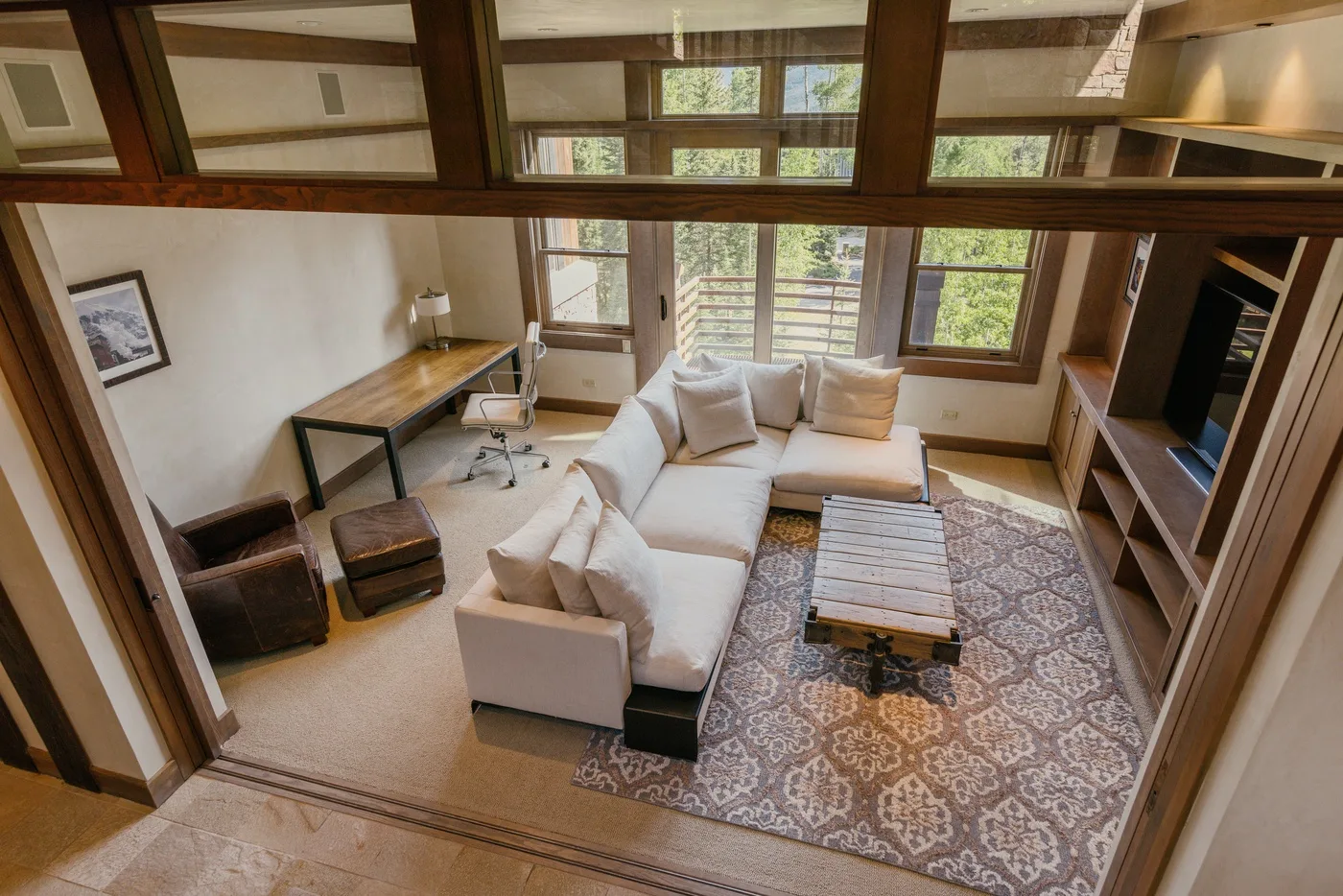 A living room with seating, a coffee table, and large windows.