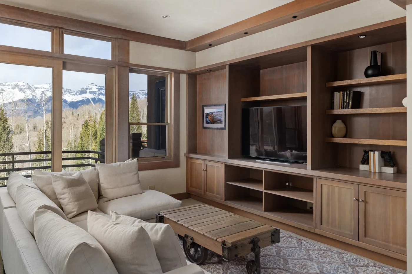 A living room with a sectional seating area, coffee table, and built-in shelving.