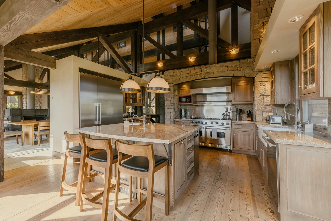 A spacious kitchen with a central island, pendant lights, and wood cabinetry.