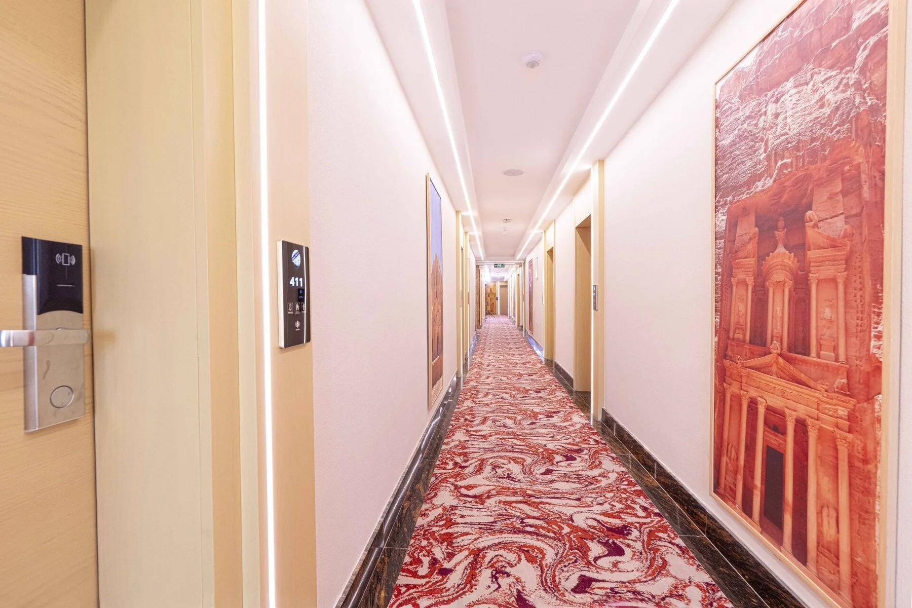 Pasillo del hotel con iluminación cálida y obras de arte de Petra