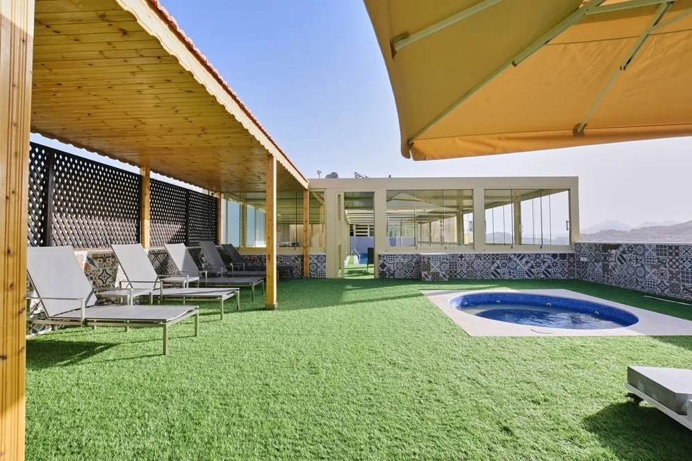 Outdoor jacuzzi and poolside lounging area