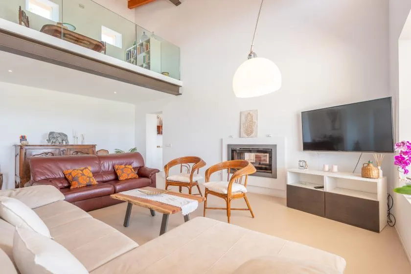 A bright living room with a fireplace, television, and seating.
